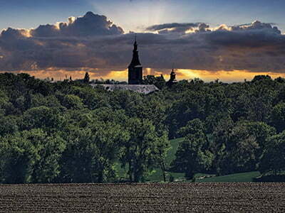 De toren van Kasteel Rolduc piekt tijdens zonsondergang boven de groene natuur uit <p>Door: Lucien Andriolo</p>