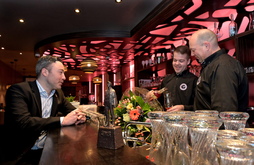 Wethouder Alexander Geers feliciteert Nick Mijnes met Lounge55, de nieuwe horecazaak aan de Markt 55 in Kerkrade. In het voormalig pand van Juliette is de 19-jarige Nick al vanaf december 2022 aan de slag met lekkere tapas en een cocktailkaart.
