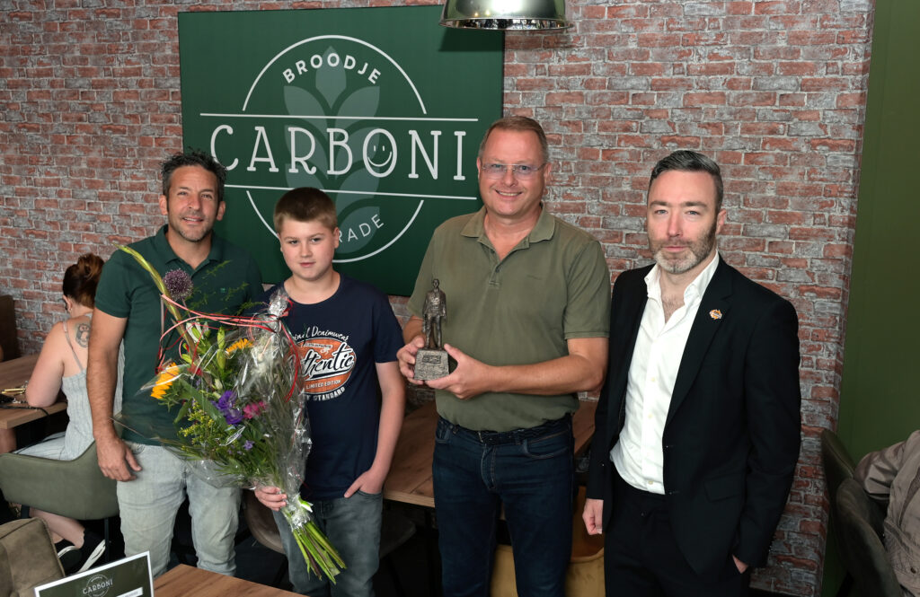 In de zomerperiode is Broodje Carboni officieel door wethouder Alexander Geers (Economische Zaken) geopend. St. Jan Baptist leerling Jordan knipte daarbij het lint door. De nieuwe broodjeszaak aan het Carboonplein is tegelijkertijd de leerwerkplek voor de leerlingen van de St. Jan Baptist school uit dezelfde wijk. “Het mes snijdt daarbij aan twee kanten”, concludeert Geers. “Aan de ene kant een nieuwe mooie onderneming, en aan de andere kant een waardevolle leerplek voor de leerlingen.