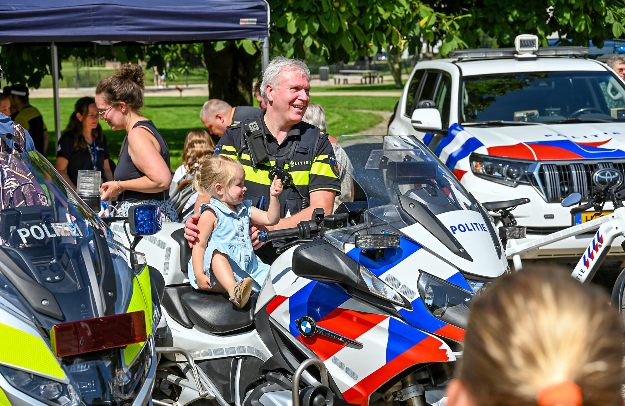 08 Een politie agent met een kindje op de politiemotor tijdens de zwaailichtendag